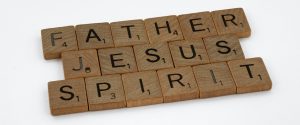 Scrabble letters spelling "Father", "Jesus", and "Spirit"